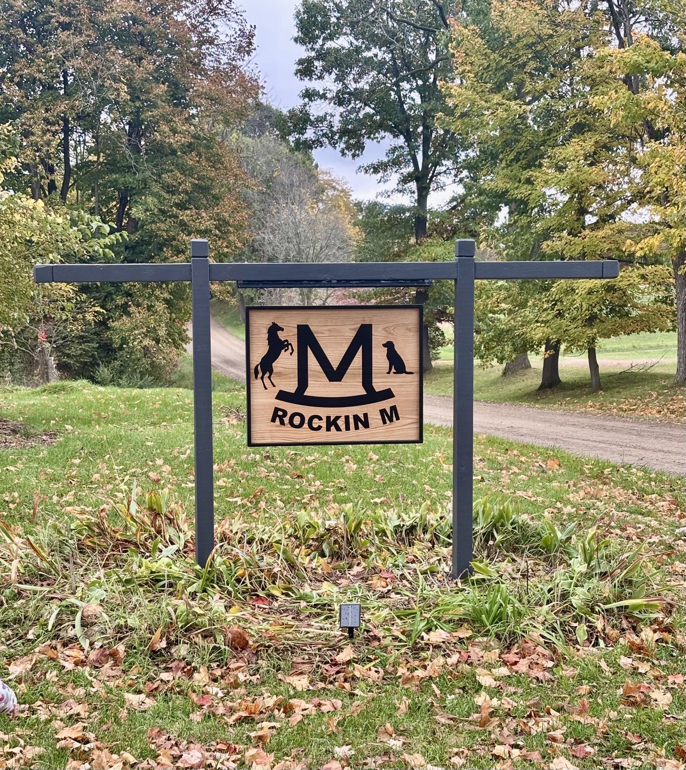 Rockin M entrance sign beside the tree-lined drive